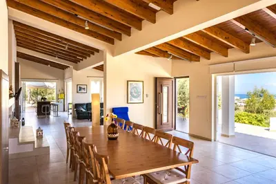 a dining room and living room with a wooden table and chairs at Marina Estate in Protaras