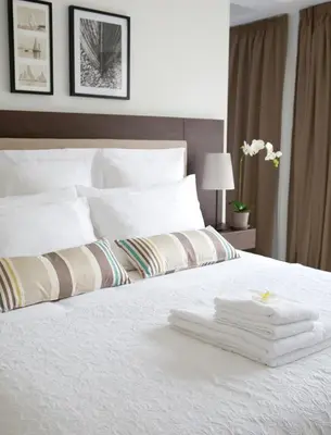 a bedroom with a white bed with towels on it at Sandy Beach Hotel & Spa - ex Sentido in Larnaka