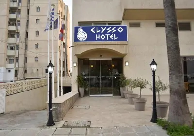 a hotel with a sign on the front of a building at Elysso Hotel in Larnaka