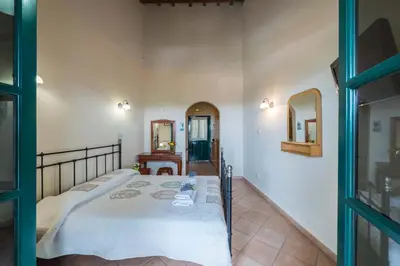 a bedroom with a bed and two mirrors at Themis House in Lemithou