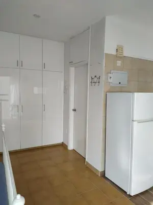 a kitchen with white cabinets and a refrigerator at MIKIS's SeaGate Studio Aprt. in Larnaka