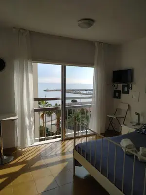 a bedroom with a bed and a large window at MIKIS's SeaGate Studio Aprt. in Larnaka