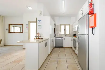 a kitchen with white cabinets and a refrigerator at Sunrise Bay Villa #1 in Paralimni