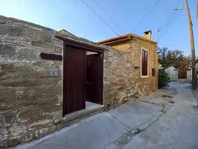 a brick building with a wooden door on it at Niovi House in Tochni