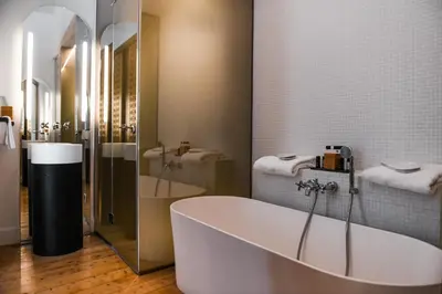 a bathroom with a tub and two sinks at S Paul City Hotel in Limassol