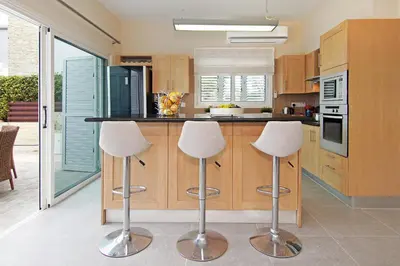 a kitchen with two bar stools and a counter at Villa Venus in Protaras