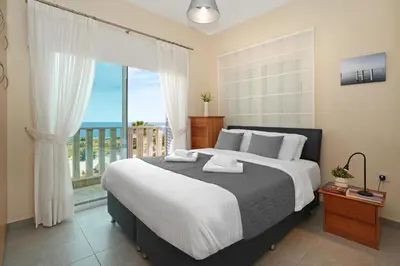 a bedroom with a large bed and a balcony at Villa Venus in Protaras