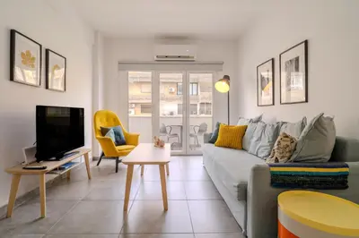 a living room with a couch and a tv at City Rendezvous One Bedroom Flat in Larnaka