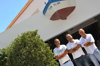 a group of three men standing in front of a building at Captain Karas Holidays Apartments in Protaras