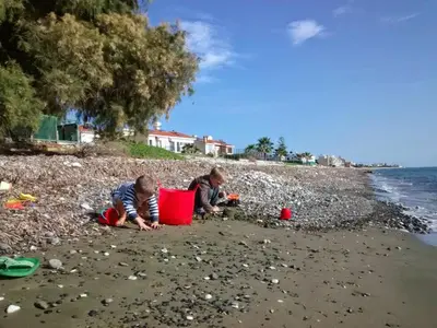 two children playing in the sand on the beach at Rita SeaView Apartment in Pervolia