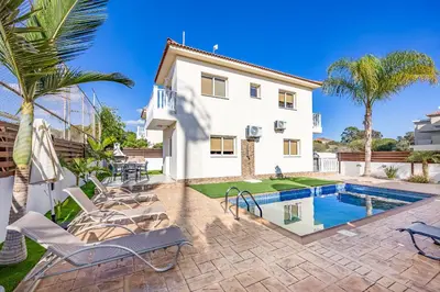 a villa with a swimming pool and palm trees at Villa Stephania in Ayia Napa