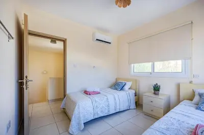a bedroom with two beds and a window at Villa Stephania in Ayia Napa