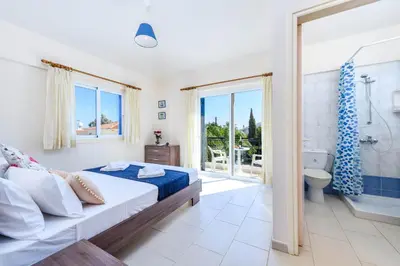 a bedroom with a large bed and a bathroom at Villa Penelope in Protaras