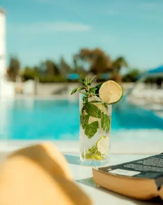 a drink with a lime on a table next to a keyboard at Sveltos Hotel in Larnaka