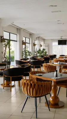 a restaurant with tables and chairs in a room at Sveltos Hotel in Larnaka