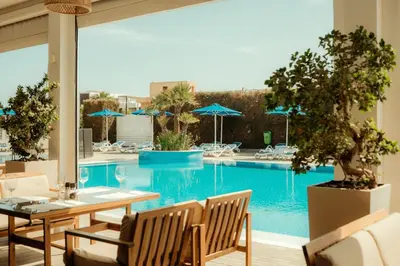 a large swimming pool with a table and chairs and a table and chairsktop at Sveltos Hotel in Larnaka