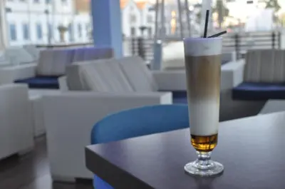 a glass of beer sitting on top of a table at Sun Hall Hotel in Larnaka