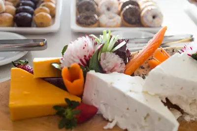 a plate of cheese and vegetables on a table with pastries at Sun Hall Hotel in Larnaka