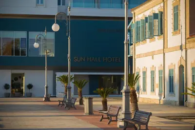 a group of benches in front of a building at Sun Hall Hotel in Larnaka