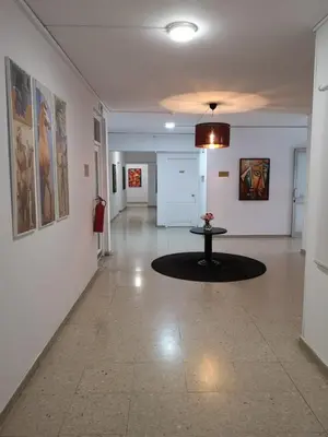 a hallway with a table in the middle of a room at Sun Hall Beach Hotel Apartments in Larnaka