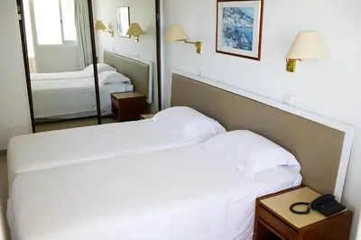 a hotel room with a bed and a mirror at Sun Hall Beach Hotel Apartments in Larnaka