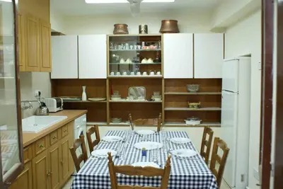 a kitchen with a table with a blue and white checkered table cloth at Yiayia's House Limassol city in Limassol
