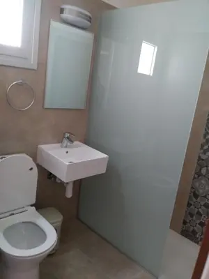 a bathroom with a white toilet and a sink at Livas Hotel Apartments in Protaras