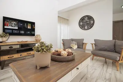 a living room with a table and a clock on the wall at Villa Maris in Protaras