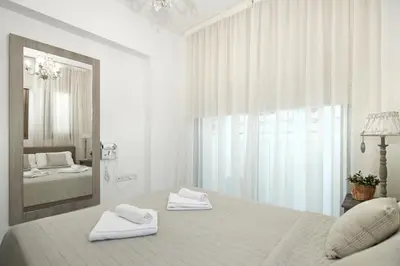 a white bedroom with a bed and a mirror at Villa Maris in Protaras