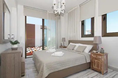a bedroom with a large bed and a chandelier at Villa Maris in Protaras