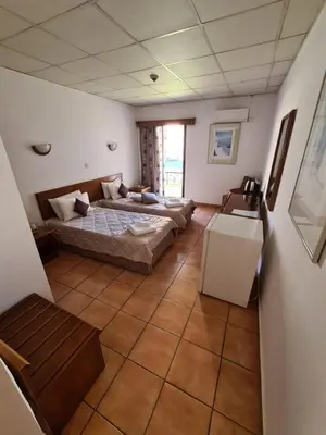 a large room with two beds and a table at Metropole Hotel in Limassol