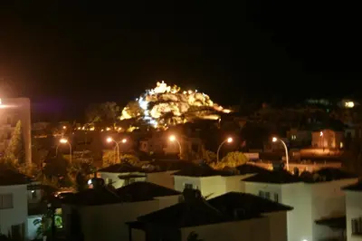 a mountain lit up at night with buildings and street lights at Mandalena Hotel Apartments in Protaras