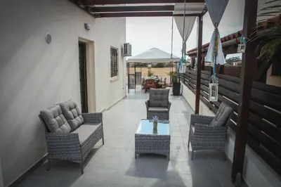 a patio with chairs and a table on a balcony at Villa Elena in Ayia Napa