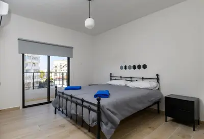 a bedroom with a large bed with blue pillows at Ollies 3 Bedroom Apartment in Larnaka