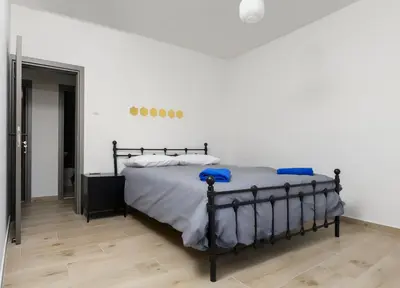 a bedroom with a bed with white sheets and blue pillows at Ollies 3 Bedroom Apartment in Larnaka