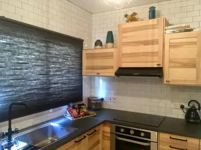 a kitchen with wooden cabinets and a sink and a stove at FatCow Beach House 43 in Larnaka