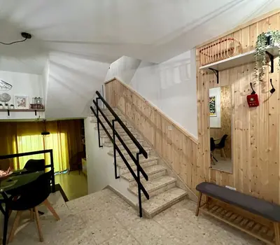 a staircase in a living room with wooden walls at FatCow Beach House 43 in Larnaka