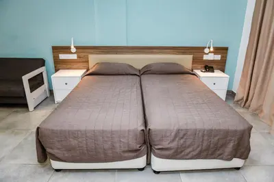 a large bed in a bedroom with two night stands at Sweet Memories Hotel Apts in Protaras