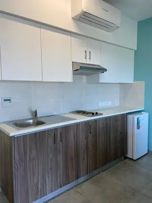 a kitchen with white cabinets and a sink and a refrigerator at Sweet Memories Hotel Apts in Protaras