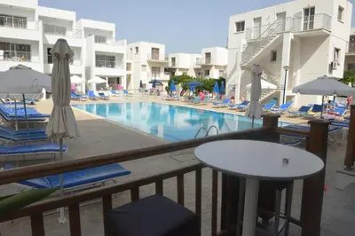 a view of a swimming pool with chairs and umbrellas at Sweet Memories Hotel Apts in Protaras