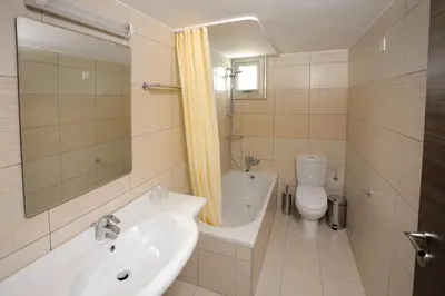 a white bathroom with a sink and a toilet at Petrosana Hotel Apartments in Ayia Napa