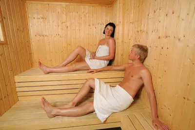 a man and woman sitting in a sauna at Petrosana Hotel Apartments in Ayia Napa