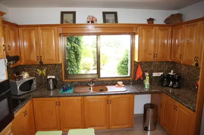 a kitchen with wooden cabinets and a sink and a window at Residence L' Aubrais in Limassol