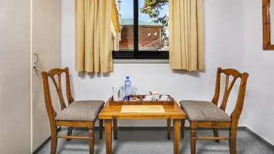 a wooden table with two chairs and a window at Troodos Hotel & Spa in Troodos
