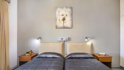 a bedroom with two beds and a painting on the wall at Troodos Hotel & Spa in Troodos
