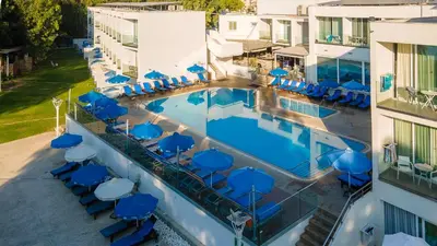 an aerial view of a hotel pool with blue chairs at Park Beach Hotel in Limassol
