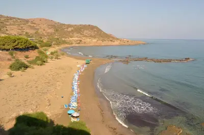 an aerial view of a beach with umbrellas and the ocean at E.J. Pyrgos Bay Hotel in Kato Pyrgos