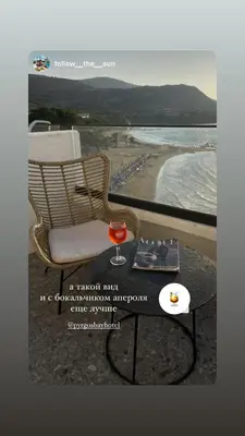 a chair and a table next to a beach at E.J. Pyrgos Bay Hotel in Kato Pyrgos