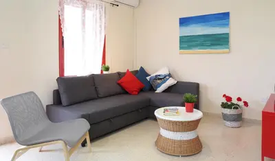 a living room with a couch and a table at Protaras Happy Sunny Holidays in Paralimni