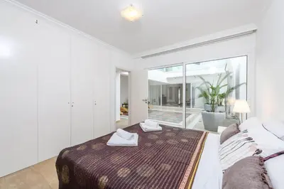 a bedroom with a bed and a large window at Villa Nausica in Protaras